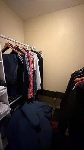 a view of walk in closet with clothes and shoes