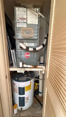a room with water heater and wooden cabinets