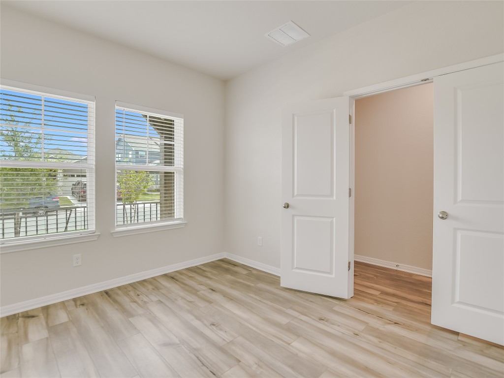 2818 Rustic Hills Drive Round Rock, TX 78665 - Photo 10 of 26 a view of an empty room with wooden floor and a window