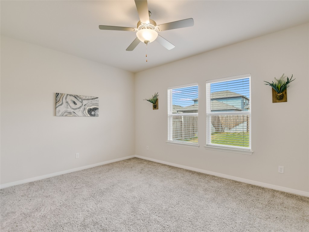 2818 Rustic Hills Drive Round Rock, TX 78665 - Photo 12 of 26 an empty room with windows and fan