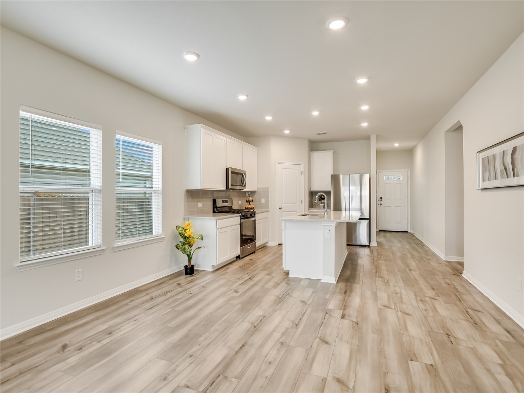 2818 Rustic Hills Drive Round Rock, TX 78665 - Photo 3 of 26 a living room with furniture and a dining table with kitchen view