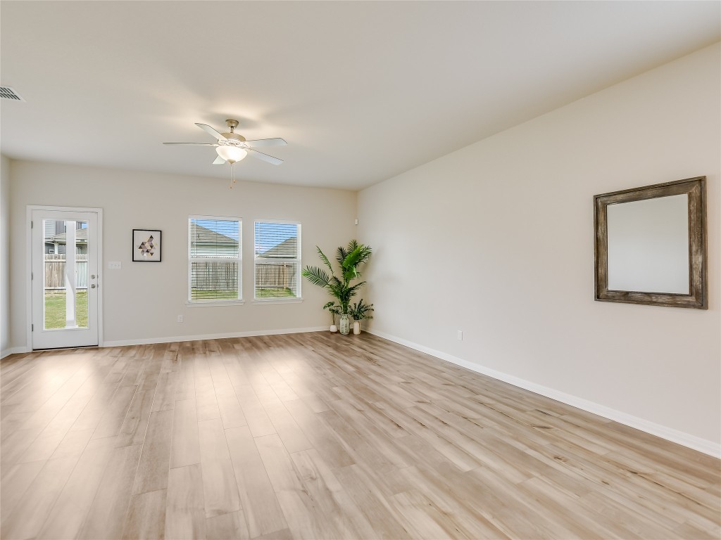 2818 Rustic Hills Drive Round Rock, TX 78665 - Photo 5 of 26 a view of an empty room with wooden floor and a window