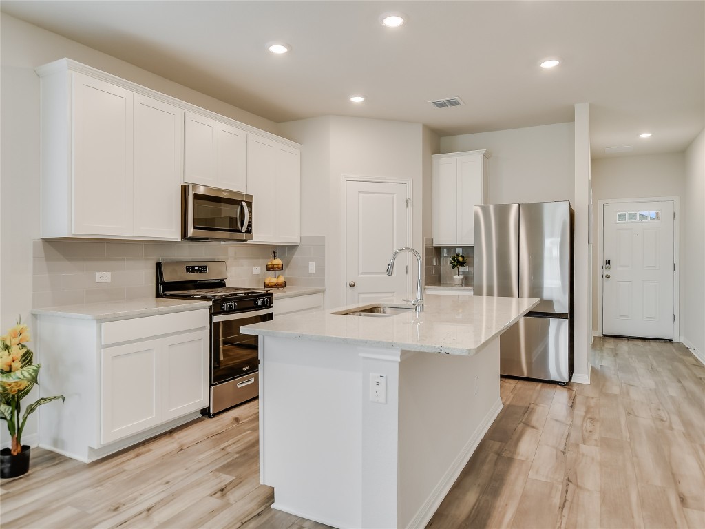 2818 Rustic Hills Drive Round Rock, TX 78665 - Photo 7 of 26 a kitchen with stainless steel appliances a microwave sink and refrigerator