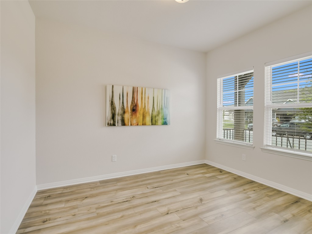 2818 Rustic Hills Drive Round Rock, TX 78665 - Photo 9 of 26 a view of an empty room with wooden floor and a window