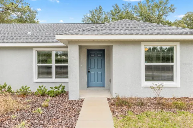 a view of a kitchen with kitchen island a sink wooden floor and a refrigerator