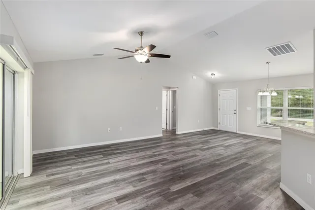 a kitchen with stainless steel appliances granite countertop white cabinets and a stove top oven