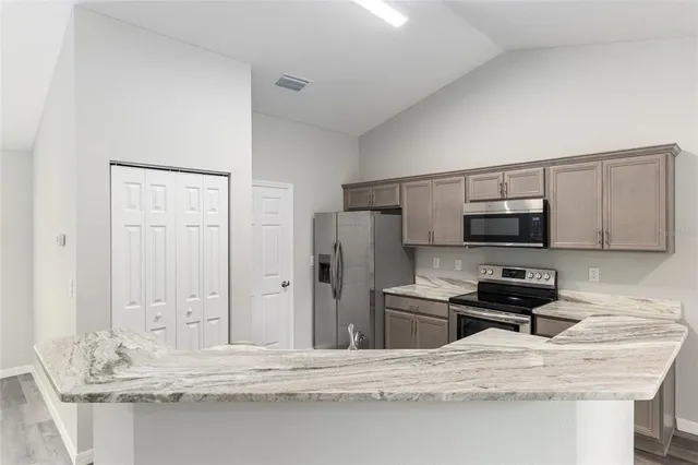 an empty room with wooden floor ceiling fan and windows