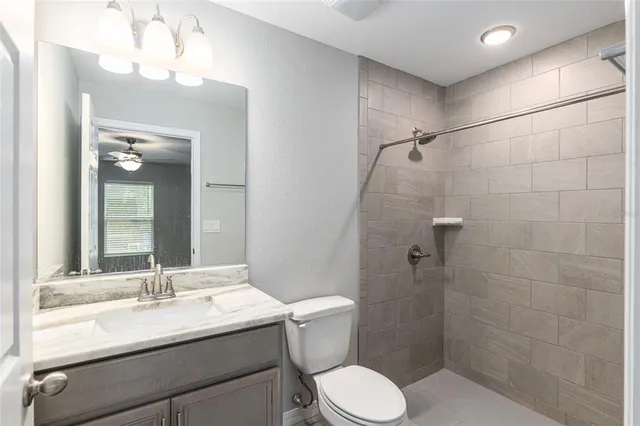 an empty room with wooden floor and a ceiling fan