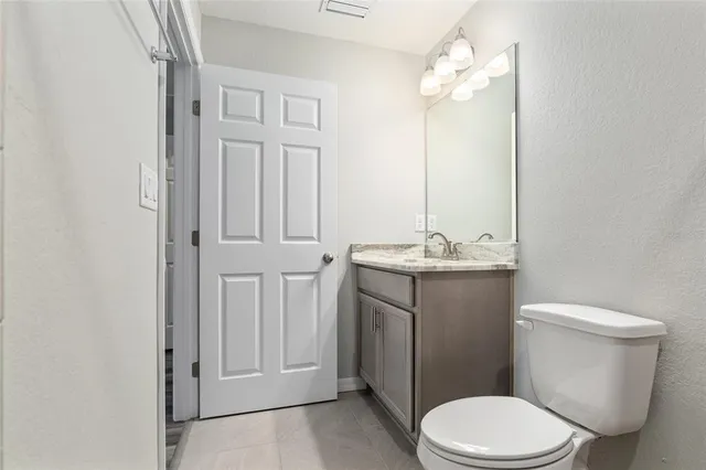 a view of an empty room with a fireplace and cabinets