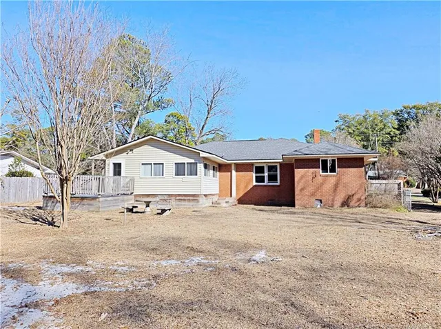 a front view of a house with a yard covered in snow