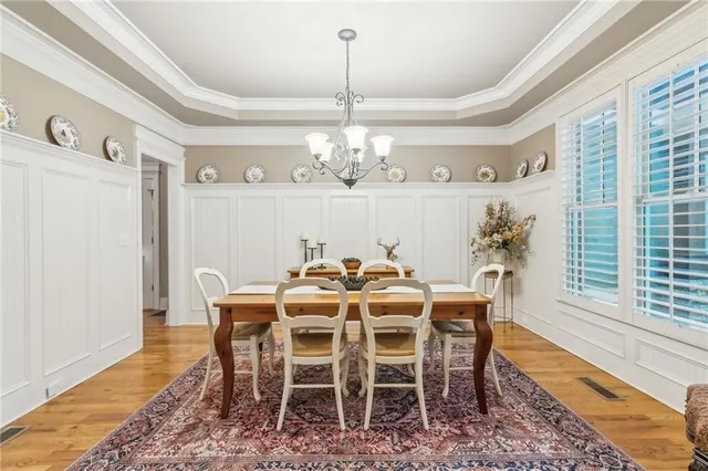 a kitchen with granite countertop a stove a sink a dining table and chairs
