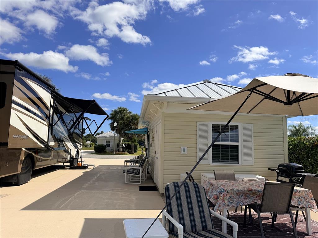 9594 Southeast 47th Way Webster, FL 33597 - Photo 12 of 50 a view of a patio with dining table and chairs with a barbeque grill and a fireplace