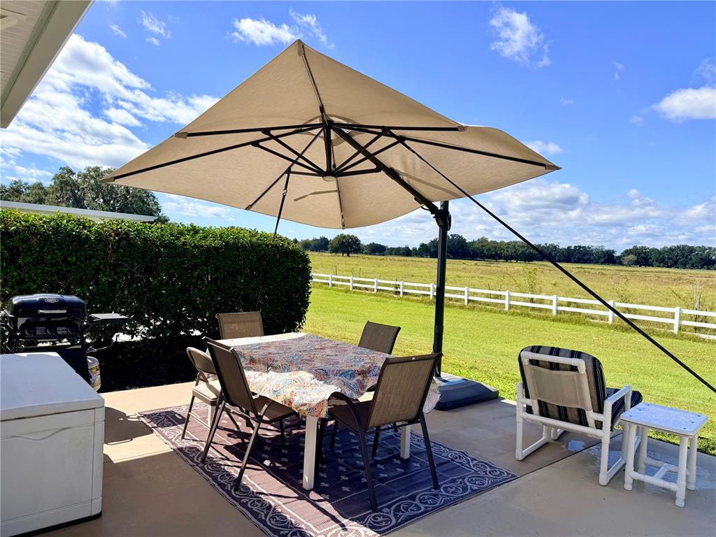9594 Southeast 47th Way Webster, FL 33597 - Photo 15 of 50 a view of an outdoor sitting area with furniture and umbrella
