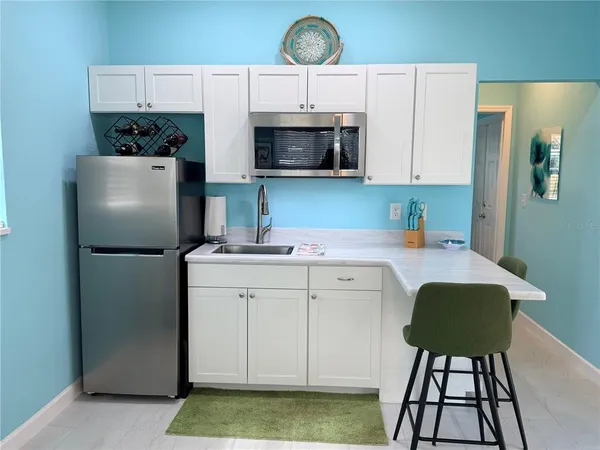 a kitchen with a stove a refrigerator and a cabinets