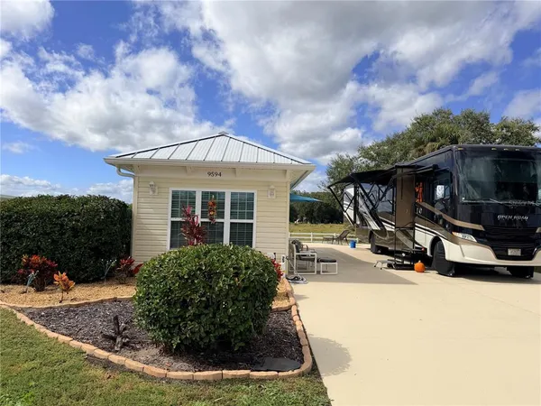a view of a house with backyard and sitting area