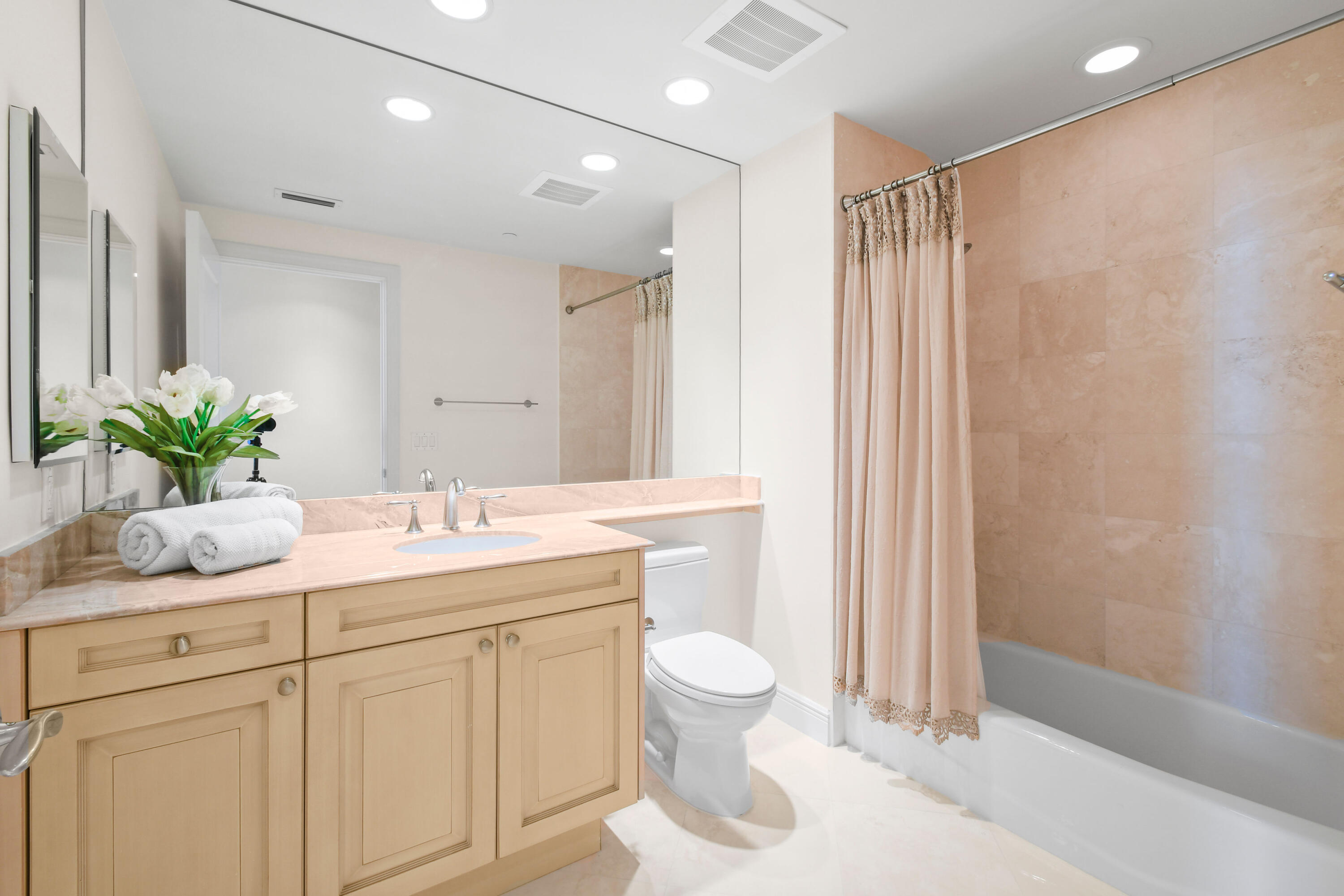 5050 North Ocean Drive, Unit 702 Singer Island, FL 33404 - Photo 18 of 40 a bathroom with a granite countertop sink a toilet and a mirror