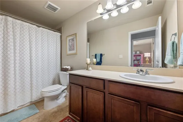 a bathroom with a double vanity sink toilet and a mirror