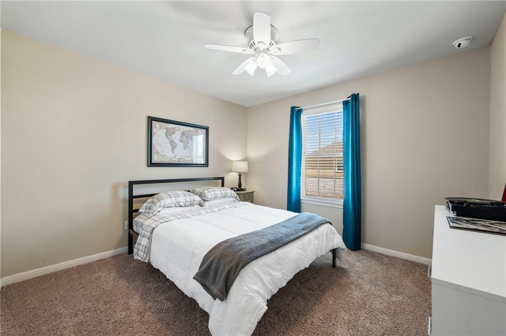 109 Hunt's Link Road Dripping Springs, TX 78620 - Photo 22 of 27 a bedroom with a bed and a chandelier