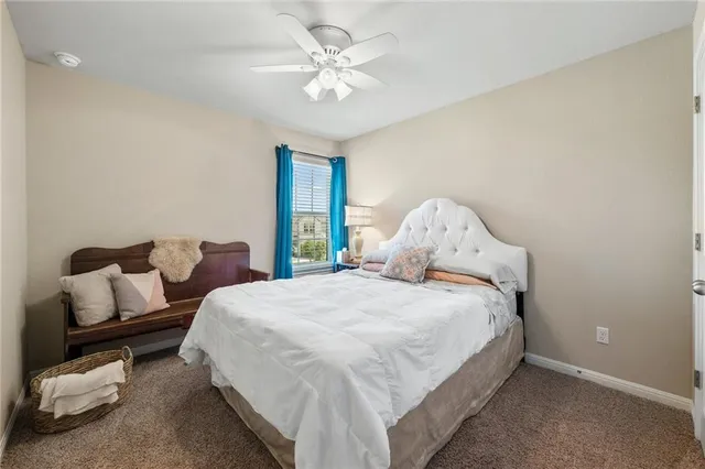 a bedroom with a bed and a ceiling fan