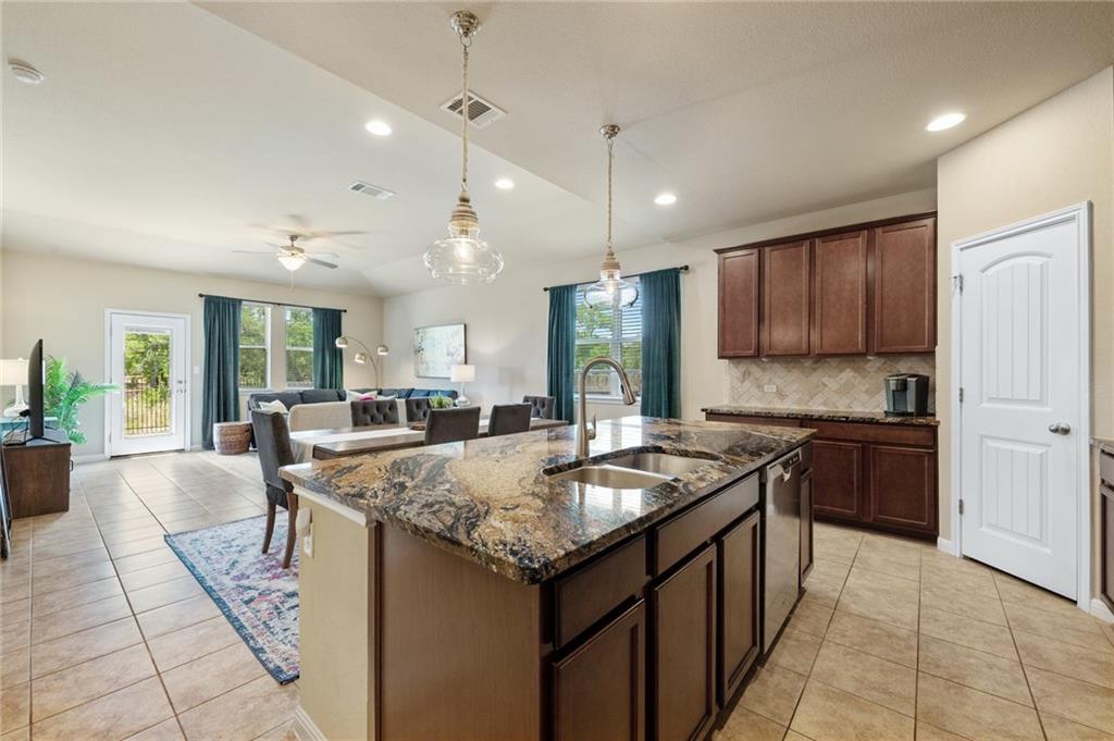 109 Hunt's Link Road Dripping Springs, TX 78620 - Photo 10 of 27 a kitchen with granite countertop kitchen island stainless steel appliances a sink stove and cabinets