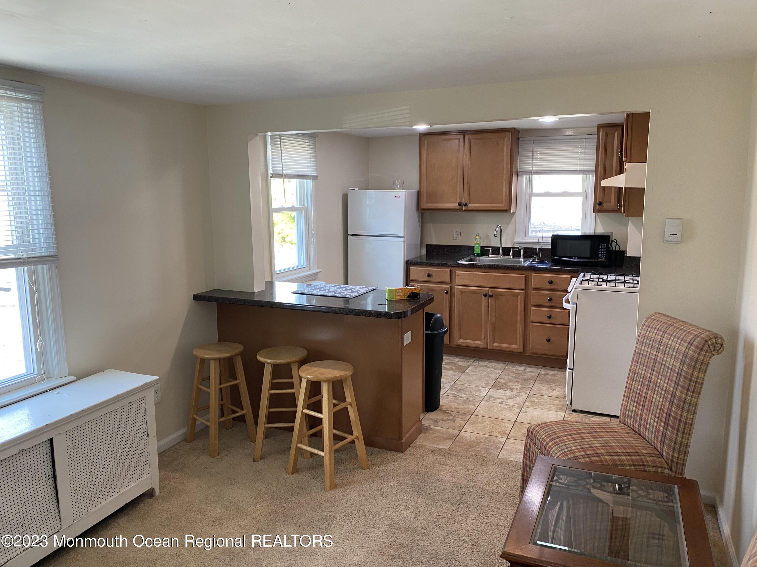 1802 Pine Terrace Lake Como, NJ 07719 - Photo 1 of 9 a kitchen with a table chairs sink and cabinets
