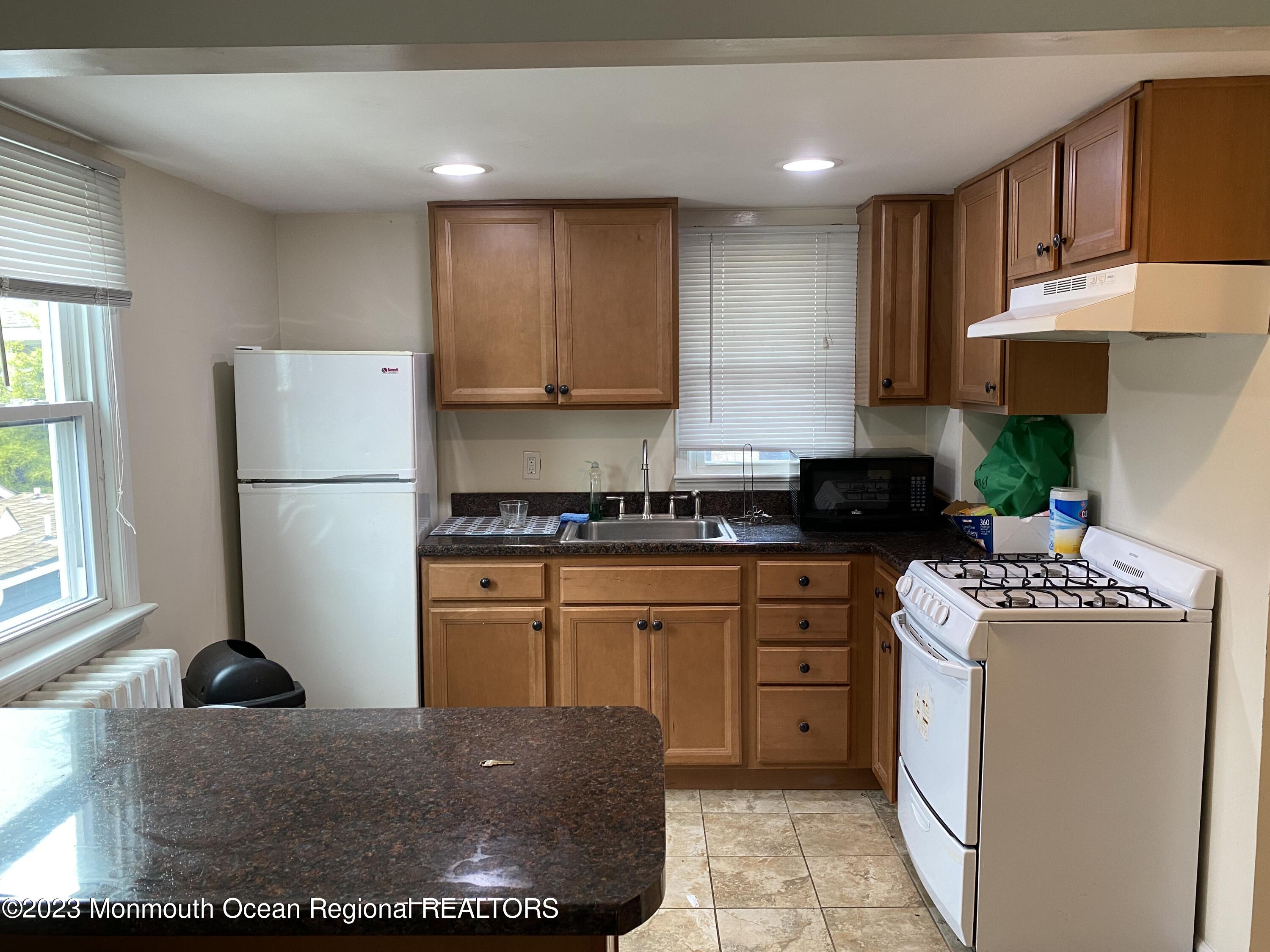 1802 Pine Terrace Lake Como, NJ 07719 - Photo 3 of 9 a kitchen with kitchen island granite countertop a sink stainless steel appliances and cabinets