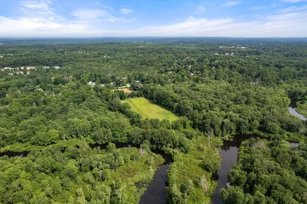 an aerial view of residential houses with outdoor space and trees