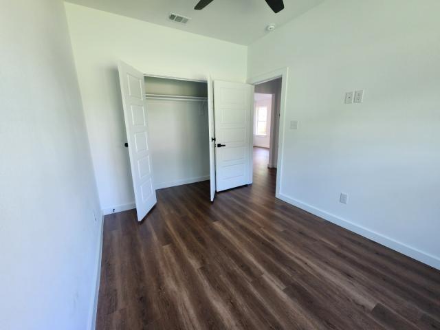 562 Jonelle Avenue Dallas, TX 75217 - Photo 14 of 20 Unfurnished bedroom with dark wood-type flooring, ceiling fan, a closet, and lofted ceiling