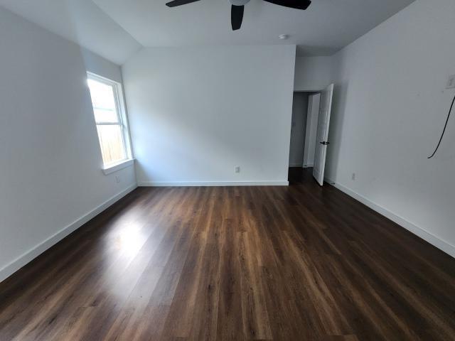 562 Jonelle Avenue Dallas, TX 75217 - Photo 19 of 20 Empty room featuring dark wood-type flooring, ceiling fan, and lofted ceiling