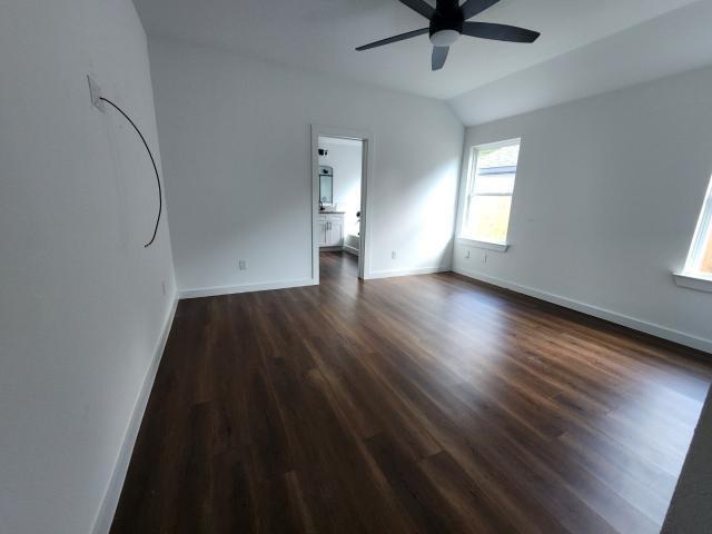 562 Jonelle Avenue Dallas, TX 75217 - Photo 20 of 20 Unfurnished bedroom featuring dark wood-style flooring, vaulted ceiling, ceiling fan, and ensuite bath