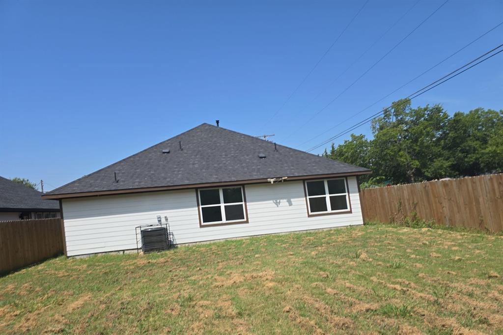 562 Jonelle Avenue Dallas, TX 75217 - Photo 4 of 20 Back of property with a fenced backyard and roof with shingles