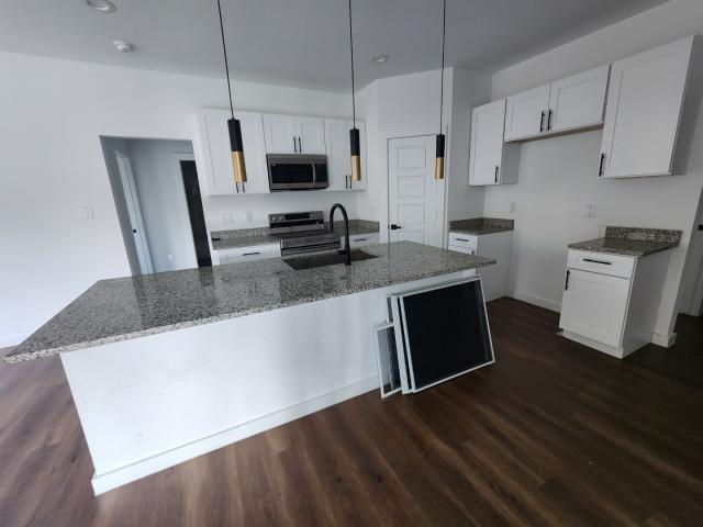 562 Jonelle Avenue Dallas, TX 75217 - Photo 6 of 20 Kitchen featuring white cabinets, dark stone countertops, and dark wood-type flooring