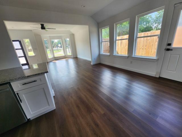 562 Jonelle Avenue Dallas, TX 75217 - Photo 9 of 20 Unfurnished living room with dark wood-style floors, a ceiling fan, and vaulted ceiling