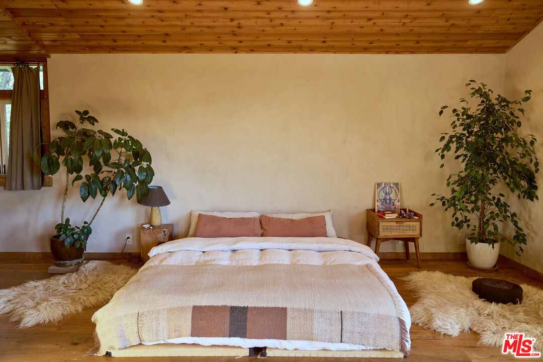 22068 Topanga School Road Topanga, CA 90290 - Photo 23 of 70 a bedroom with a bed and a potted plant