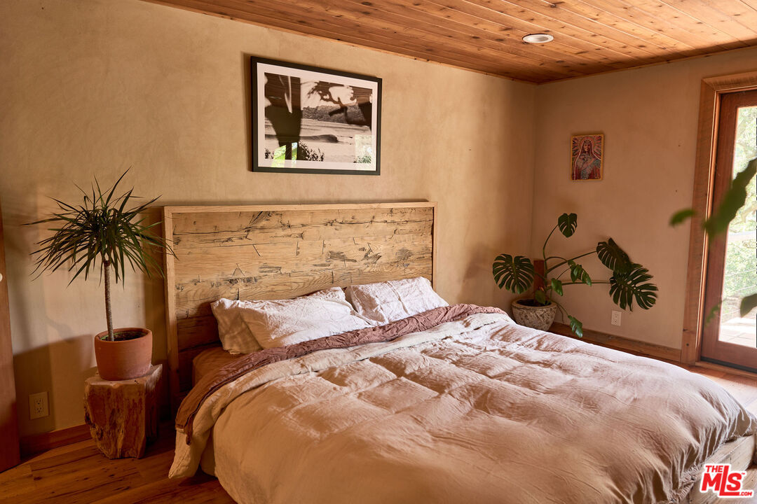 22068 Topanga School Road Topanga, CA 90290 - Photo 37 of 70 a bedroom with a bed and a painting on the wall
