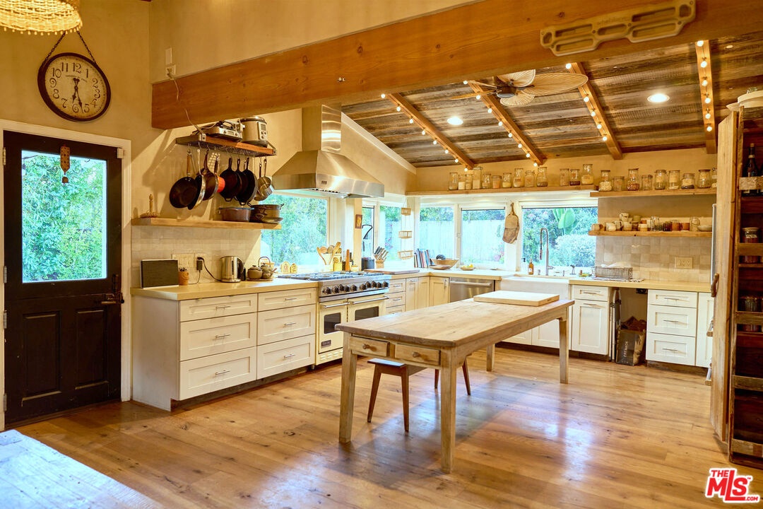 22068 Topanga School Road Topanga, CA 90290 - Photo 7 of 70 a room with stainless steel appliances kitchen island granite countertop a stove a sink and white cabinets with wooden floor