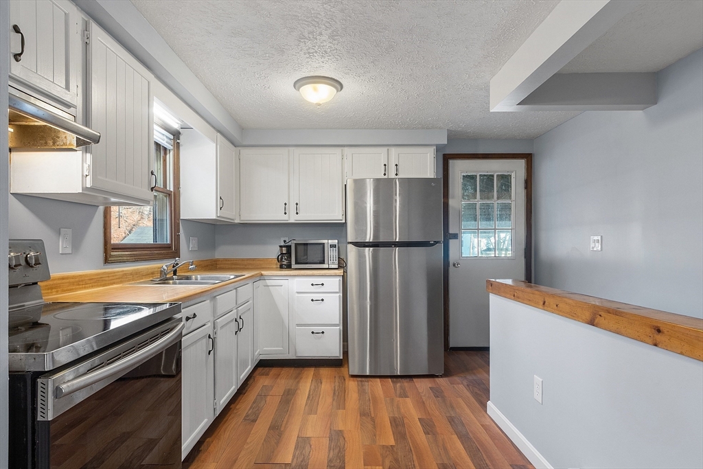 5 Catherine Street Clinton, MA 01510 - Photo 7 of 29 a kitchen with a refrigerator a sink and wooden floor