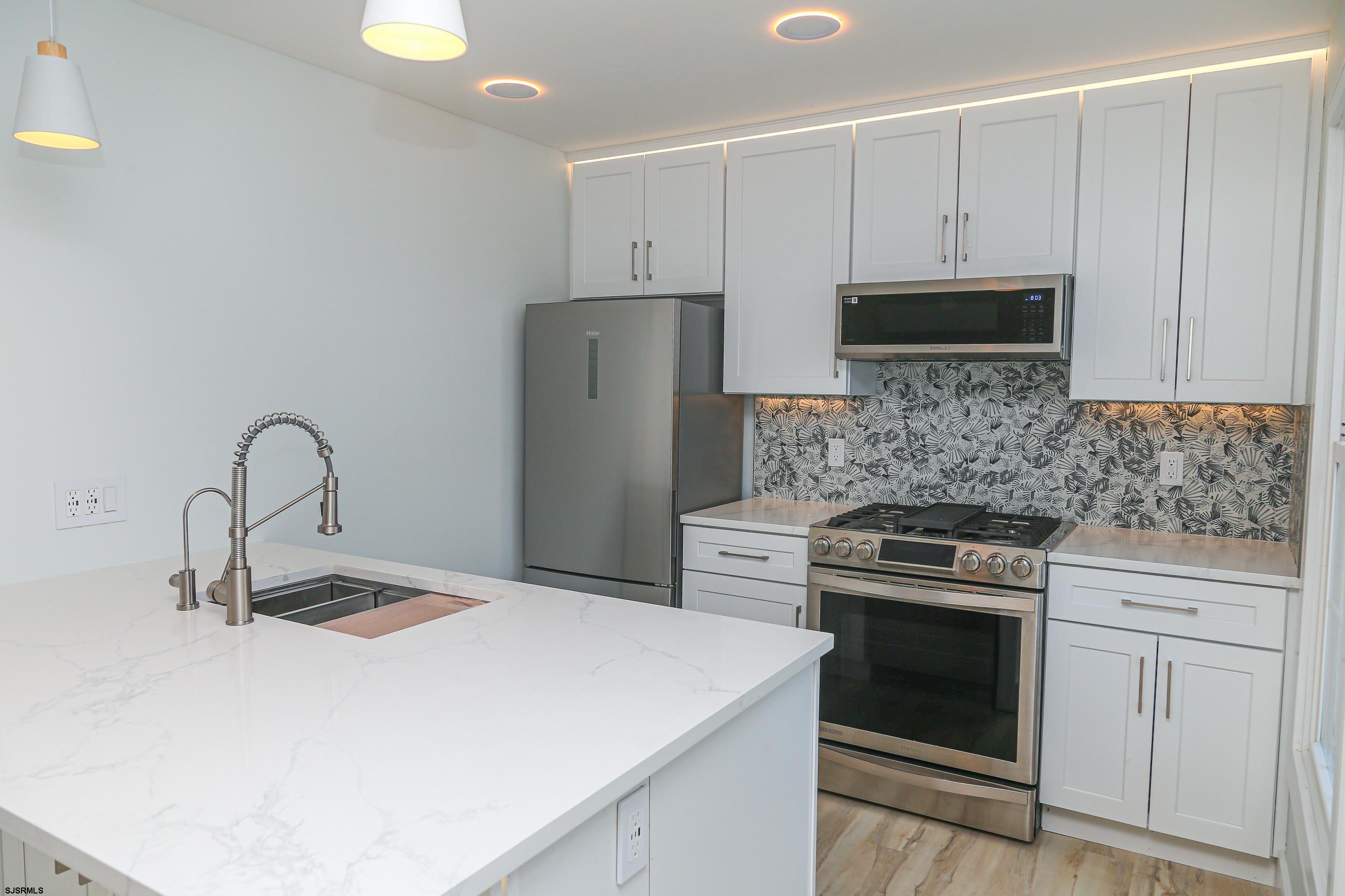 169 40th Street South, Unit 38 Brigantine, NJ 08203 - Photo 11 of 79 a kitchen with stainless steel appliances a stove microwave and sink