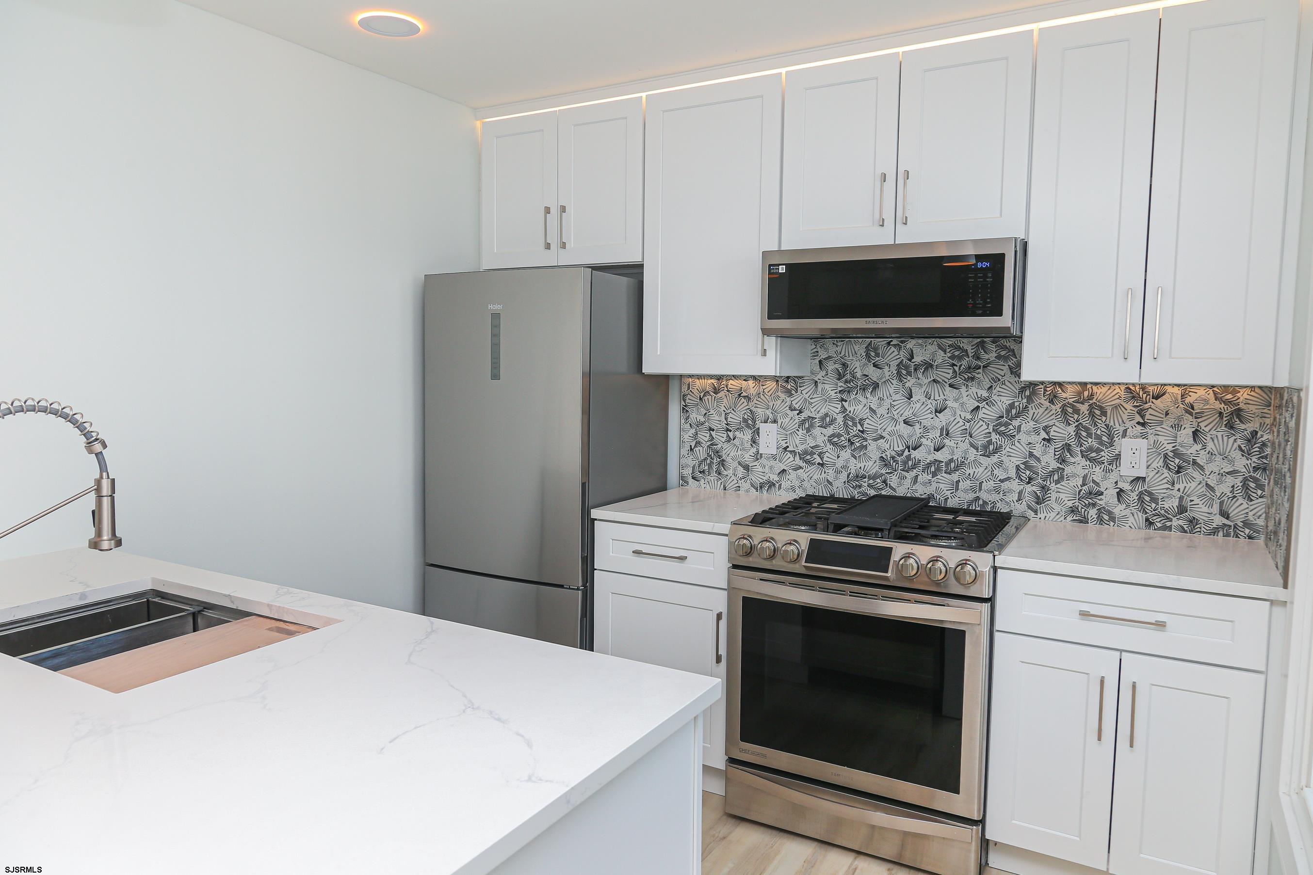 169 40th Street South, Unit 38 Brigantine, NJ 08203 - Photo 15 of 79 a kitchen with granite countertop white cabinets and stainless steel appliances