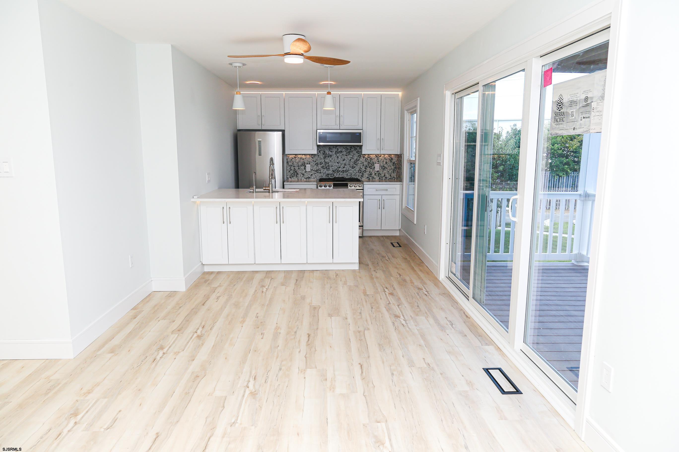 169 40th Street South, Unit 38 Brigantine, NJ 08203 - Photo 6 of 79 a kitchen with stainless steel appliances kitchen island granite countertop a refrigerator a sink a stove and white cabinets with wooden floor
