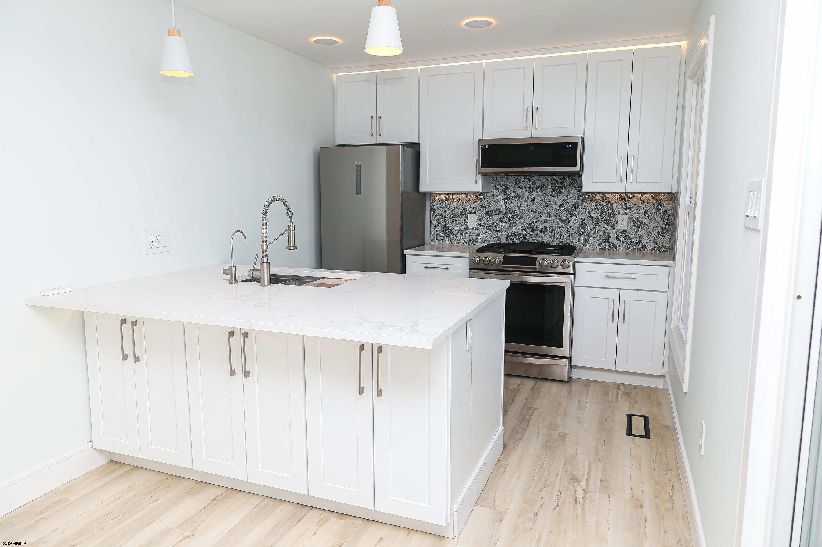 169 40th Street South, Unit 38 Brigantine, NJ 08203 - Photo 8 of 79 a kitchen with stainless steel appliances a stove refrigerator sink and cabinets