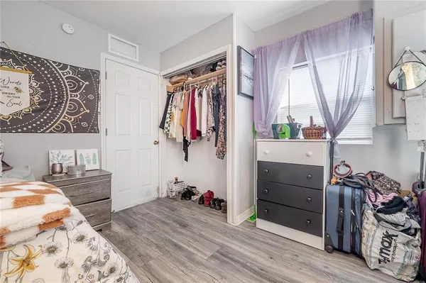 a bedroom with a bed and a flat tv screen on the dresser