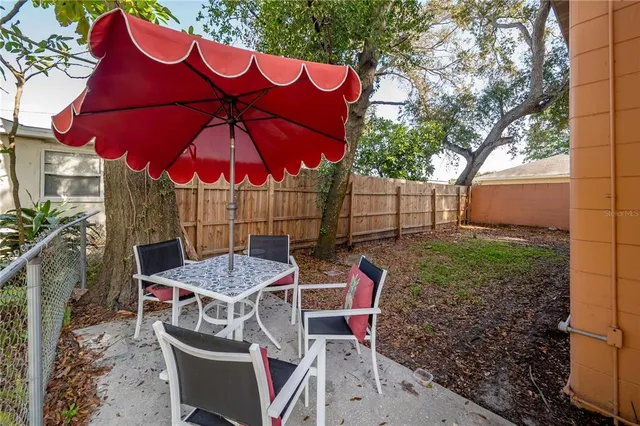 a view of a patio with table and chairs under an umbrella