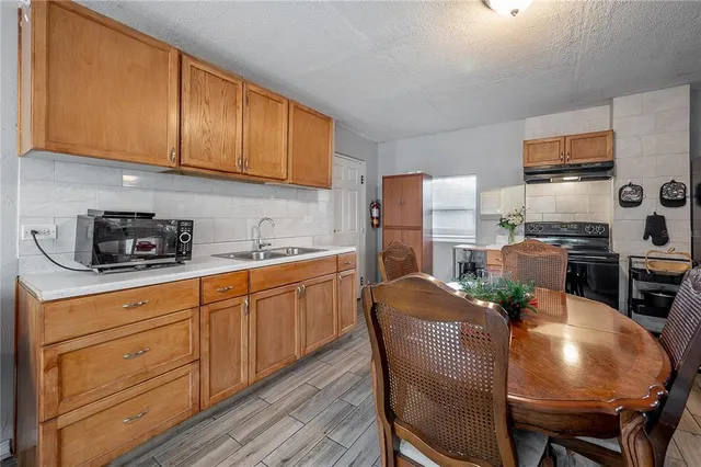 a kitchen with stainless steel appliances granite countertop a table chairs microwave and sink