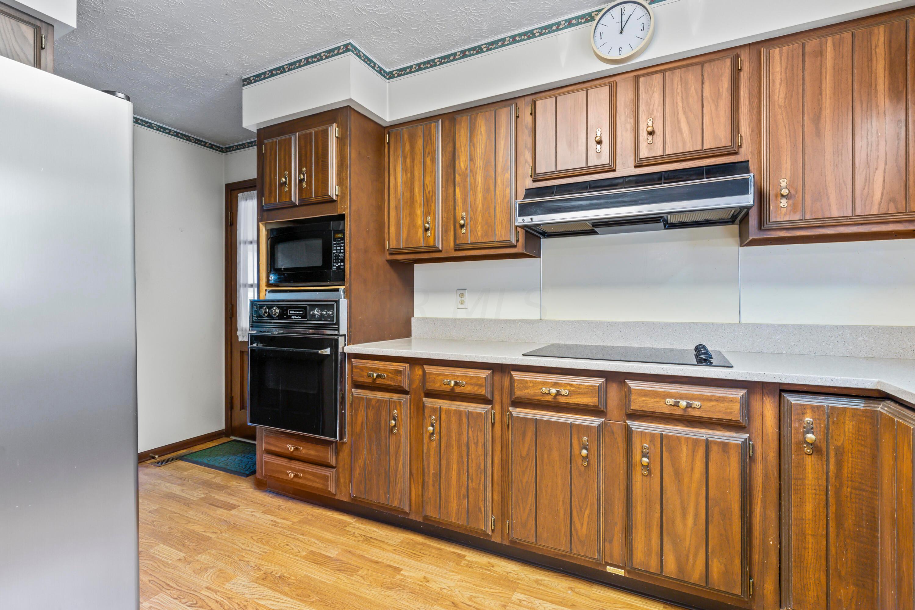 5764 Cheshire Road Galena, OH 43021 - Photo 29 of 59 • Laminate flooring
• Ivory painted walls
• Ceiling light
• Fluted wood cabinets
• Updated granite countertops
• JennAir® dishwasher
• Disposal
• Range hood
• Lazy Susan
• General Electric® electric
range top
• Kenmore® refrigerator
• Planning desk
• JennAir® oven
• General Electric® microwave