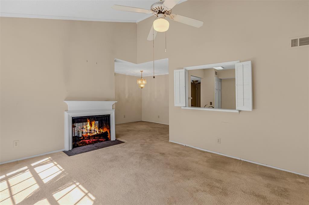 an empty room with fireplace and fan