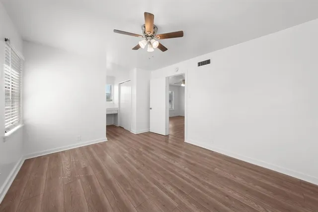 a view of a livingroom with wooden floor and a ceiling fan