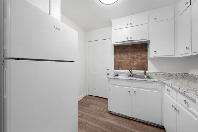 a kitchen with stainless steel appliances white cabinets and a refrigerator