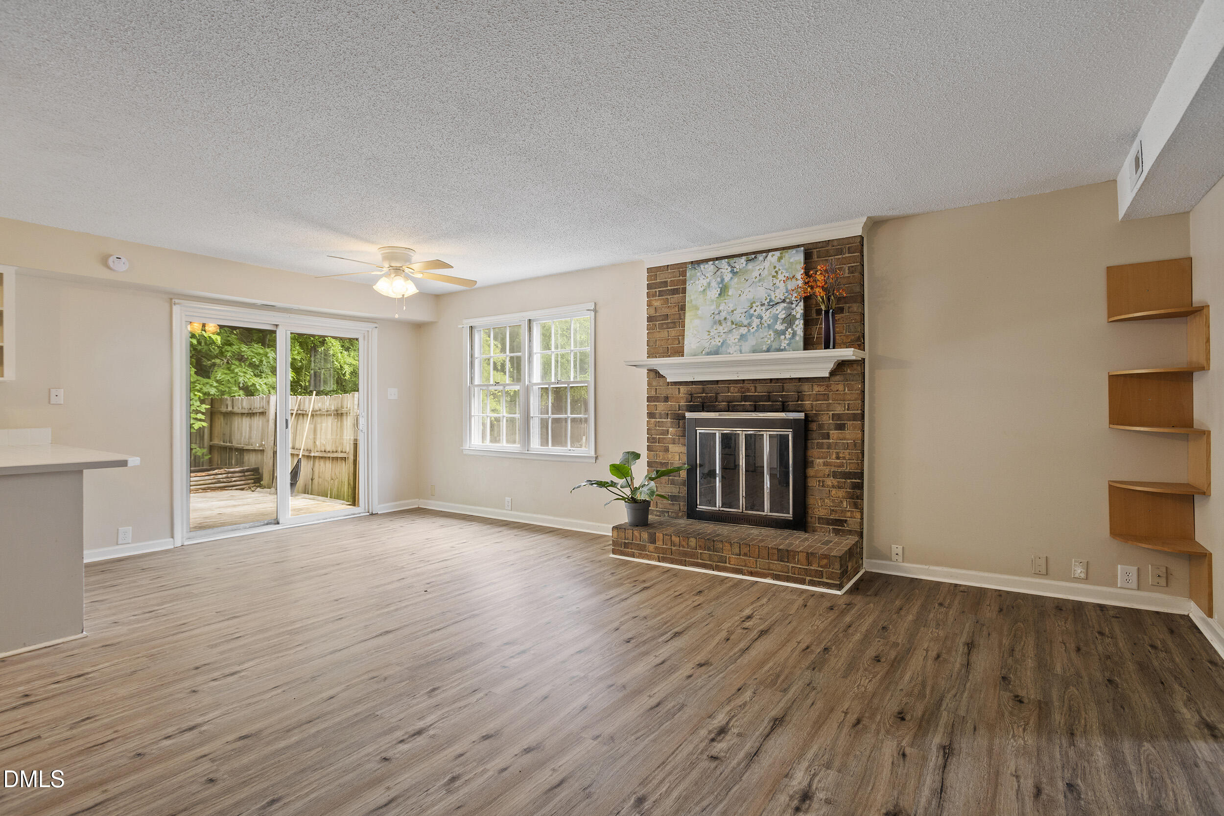 1801 Quail Ridge Road Raleigh, NC 27609 - Photo 2 of 29 an empty room with wooden floor fireplace and windows