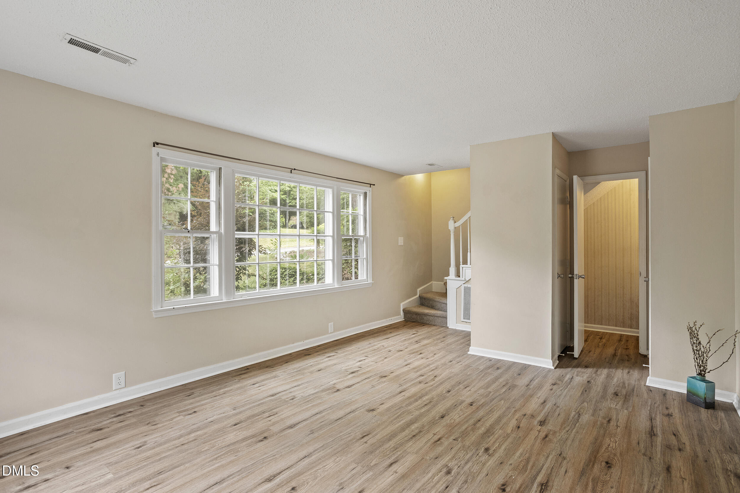 1801 Quail Ridge Road Raleigh, NC 27609 - Photo 6 of 29 a view of an empty room with wooden floor and a window